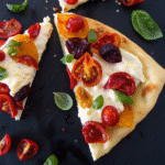 Authentic Italian Pizza Dough: Rustic Perfection from the Old Country 33 Authentic Italian pizza dough crust sliced and topped with colorful tomatoes
