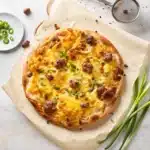 Breakfast pizza recipe step showing assembled crust with toppings