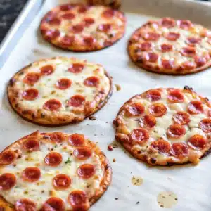 easy mini pizza on a rustic wooden board with melted cheese and fresh toppings