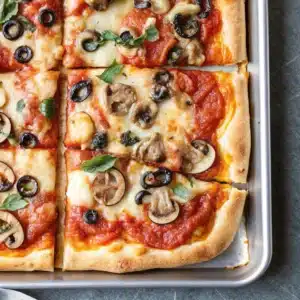 Sheet pan pizza with golden crispy crust fresh out of the oven